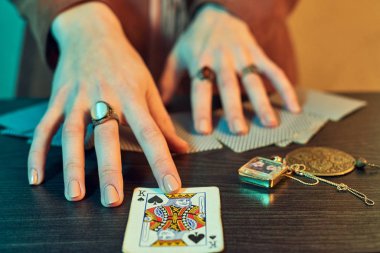 Oyun kartlarını gösteren mücevherlerle falcı elleri