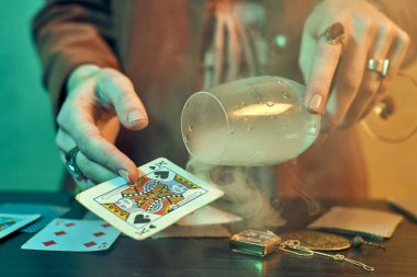 Oyun kartlarını gösteren mücevherlerle falcı elleri