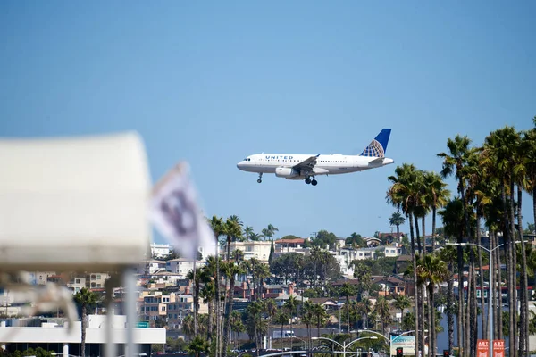 United Airlines airplane flying above the city. — Stock Photo, Image