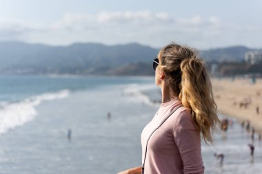 Los Angeles sahilindeki mutlu sarışın kadın.