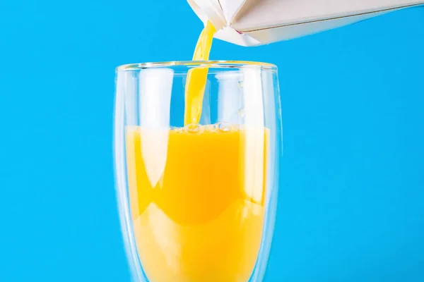 Häll Apelsinjuice Ett Glas Isolerad Blå Bakgrund — Stockfoto