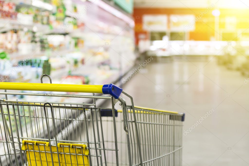 Cart at the grocery store. Abstract blurred photo of store with trolley in department store bokeh background. New ideas in trade and business.Advertising of food products. Shopping at the hypermarket.