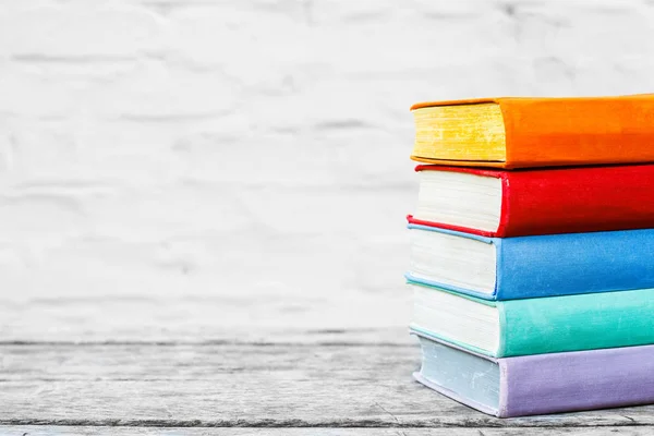 Boeken over de oude houten tafel op de witte achtergrond. Concept: terug naar school, onderwijs. — Stockfoto