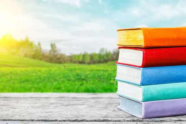 Boeken over de oude houten tafel op de achtergrond van de natuur. Concept: terug naar school, onderwijs. — Stockfoto