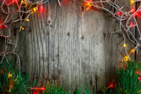 Colorful Christmas garland lights on wooden rustic background. Christmas decorations.  Holiday mood. Beautiful New Year composition.