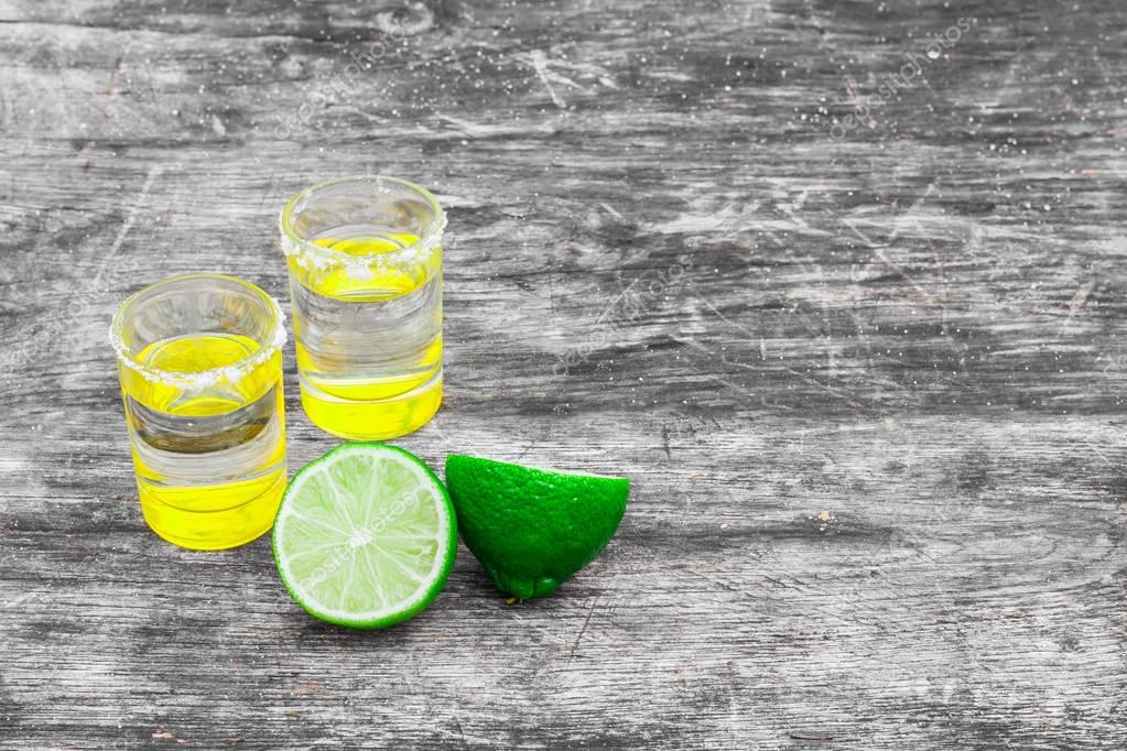 Shot Glasses With Golden Mexican Tequila Lime Slices And Salt Shot Glasses With Golden Mexican Tequila Lime Slices And Salt On Old Wooden Table