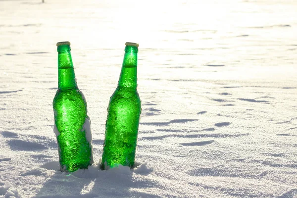 Δύο μπουκάλια κρύα μπύρα στο χιόνι κατά το ηλιοβασίλεμα. Κλείνω πάνω θέα. — Φωτογραφία Αρχείου
