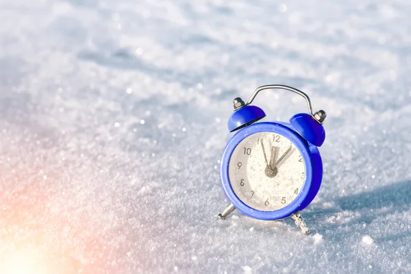 Vintage alarm clock on the snow at sunset. The concept of Christmas and New Year. Magic composition. Switched to winter time. Good morning. Waiting of holiday. — Stock Photo, Image
