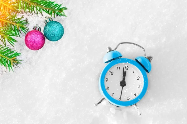 Vintage alarm clock, christmas tree branch and decoration on the snow at sunset. The concept of Xmas and New Year. Magic composition. Switched to winter time. Good morning. Waiting of holiday. — Stock Photo, Image