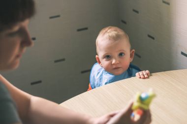 Bebek mutfak yemek yeme. Anne Çocuk besleyecek.