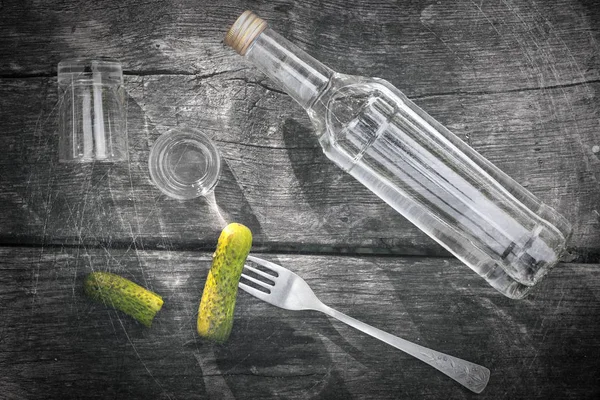 Votka salatalık turşusu ve iki fondip bardakları siyah ahşap zemin ile.