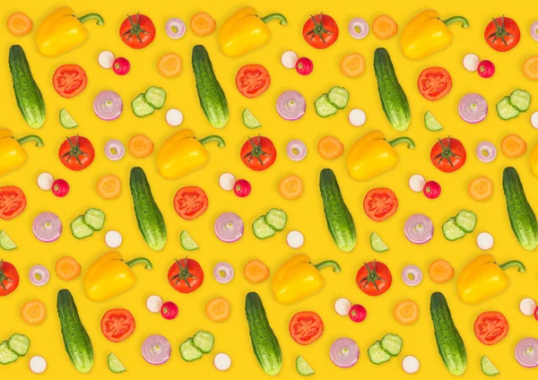 Vegetable mix on yellow isolated background. Fresh yellow pepper, chopped tomatoes, onion, round cucumber slice, carrot, radish. The concept of a healthy lifestyle. Vegetarian food.