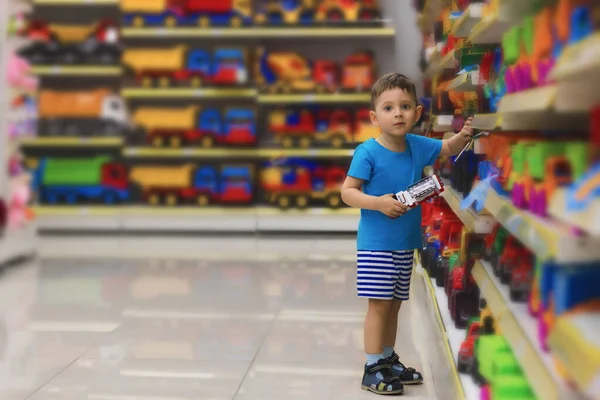 Small child choosing toys at the kid's store. Shopping for children.