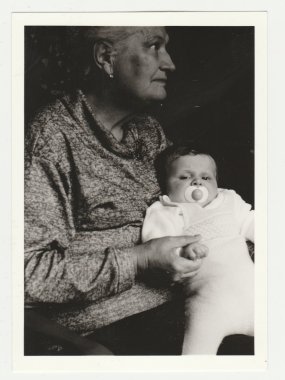 Vintage fotoğraf gösterileri büyükanne masa üstü şarj aletler todlder kukla ile. Retro siyah ve beyaz fotoğraf.
