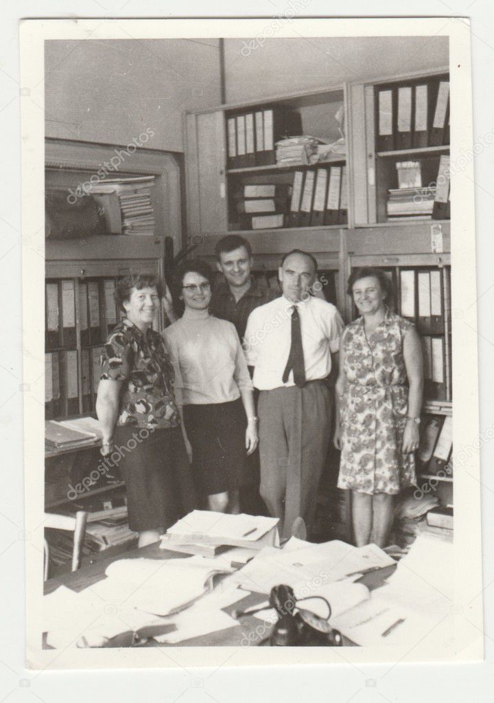 THE CZECHOSLOVAK SOCIALIST REPUBLIC - CIRCA 1980s: Vintage photo shows people (colleagues) pose in the retro office. Retro black & white  photography.