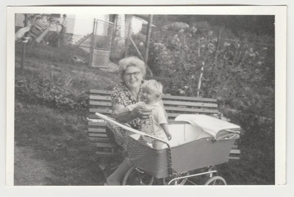 Photo vintage montre grand-mère tient un tout-petit dans le landau (chariot). Photographie rétro noir & blanc . — Photo