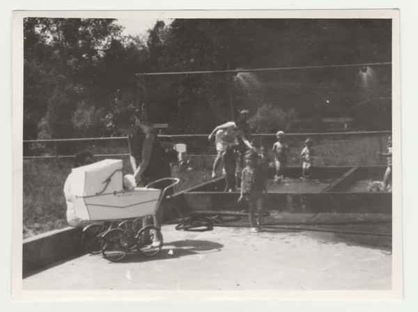 Foto vintage muestra madres con niños en el patio de recreo (duchas al aire libre). Fotografía en blanco y negro retro . — Foto de Stock