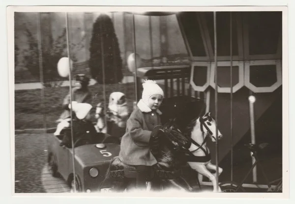 Archiwalne zdjęcie pokazuje dzieci na placu zabaw. Dzieci i karuzela. Retro czarny & biały Fotografia. — Zdjęcie stockowe