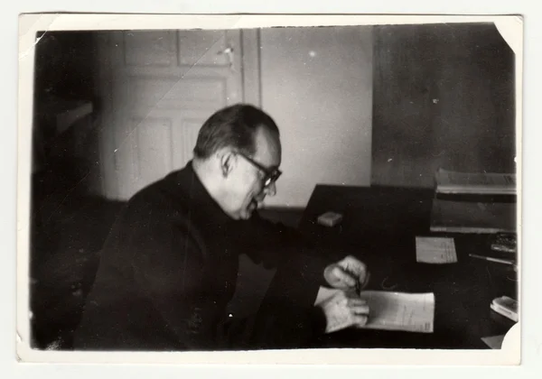 Foto vintage mostra homem senta-se na mesa. Fotografia retro preto & branco . — Fotografia de Stock