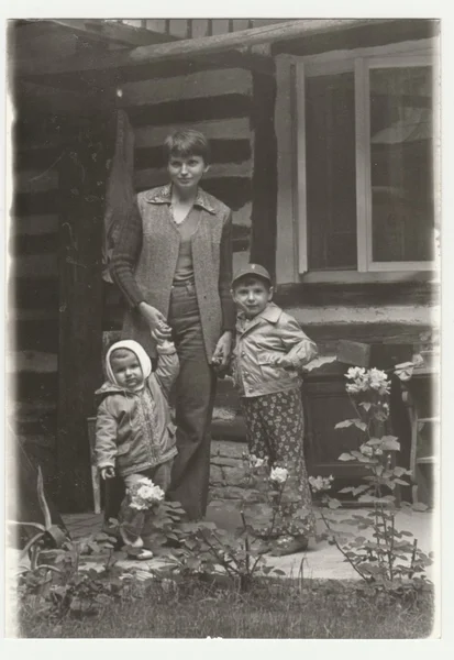 Vintage fotó mutatja egy kamasz lány, két gyermek. Jelentenek, gerendaház előtt. Retro fekete & fehér fotózás. — Stock Fotó