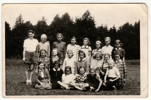 Vintage photo shows a group of girls (about ten years old) poses outdoors. Retro black & white  photography. — Stock fotografie