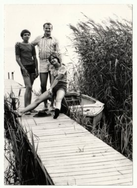 Vintage Fotoğraf baba ve ergen (genç) çocuk iskelede poz gösterir. İskele ve tekne - yaz tatilleri (tatil) Tema. 