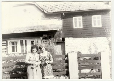 Vintage Fotoğraf kadın kır evi önünde stand gösterir. Retro siyah ve beyaz fotoğraf.