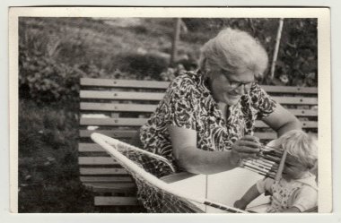 Vintage Fotoğraf büyükanne küçük bebek arabası (taşıma) gösterir. Büyükanne abacus tutar. Retro siyah ve beyaz fotoğraf 