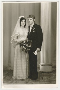 Vintage Fotoğraf bir gelin damat ile gösterir. Gelin yumuşak Duvak takıyor ve düğün çiçekleri (buket) tutar. Retro siyah ve beyaz fotoğraf.