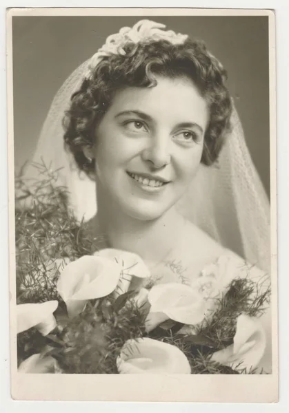 Vintage foto visar en brud. Bruden bär en mjuk slöja och innehar calla blommor (bukett). Retro svart & vit fotografi. — Stockfoto