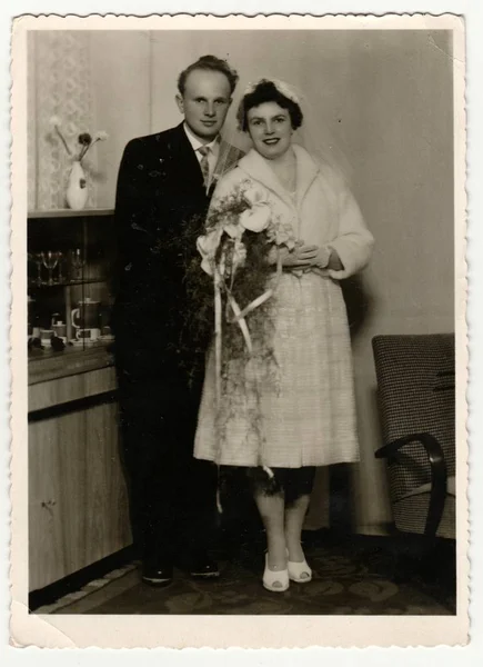 Vintage foto toont een bruid met de bruidegom. Bruid draagt een sluier van zachte en houdt calla bloemen (boeket). Retro zwart & wit fotografie. — Stockfoto