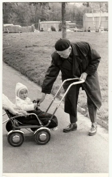 Vintage Fotoğraf dedesi küçük bebek arabası (taşıma) gösterir. Retro siyah ve beyaz fotoğraf — Stok fotoğraf