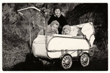 Vintage Fotoğraf küçük çocuk ve bebek arabası (başı) kışın gösterir. Retro siyah ve beyaz fotoğraf.