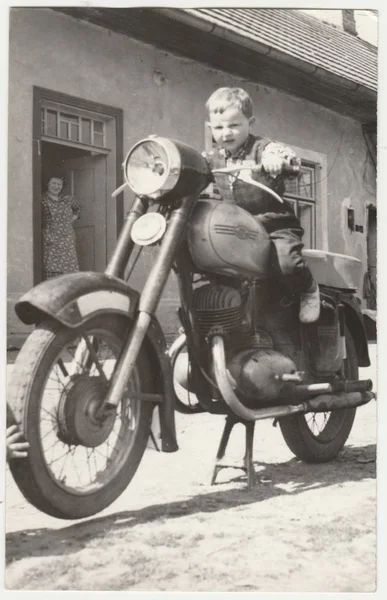 Foto vintage mostra menino senta-se na motocicleta vintage. Retro preto & fotografia branca — Fotografia de Stock