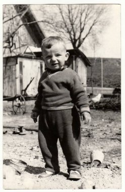 Vintage Fotoğraf arka bahçede küçük bir çocuk duruyor gösterir. Retro siyah ve beyaz fotoğraf.
