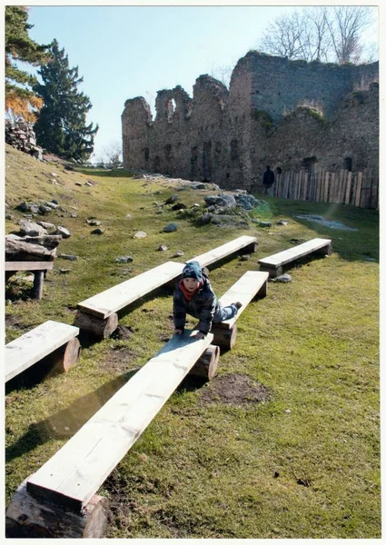 Foto retrô mostra menino pequeno na frente do castelo antigo (ruínas) Menino em uma viagem de outono. Férias (férias) viagem. Fotografia de cor vintage . — Fotografia de Stock