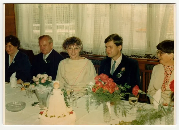Retro fotoğraf yeni evliler ve düğün konukları düğün bayram sırasında gösterir. Vintage renkli fotoğraf.