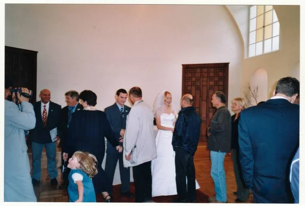 Foto retro muestra a los recién casados e invitados a la boda durante la ceremonia de la boda. Invitado felicita a la novia por el matrimonio. Fotografía a color vintage . — Foto de Stock