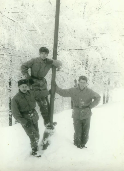 Foto retrô mostra jovens homens (soldados) durante o inverno. Os soldados posam ao ar livre (tempo nevado). Fotografia vintage — Fotografia de Stock