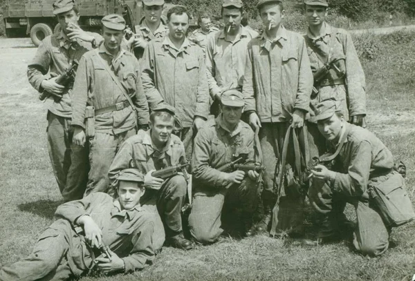 Foto retrô mostra jovens homens (soldados) posar ao ar livre. Os soldados têm sub-metralhadoras. Fotografia vintage . — Fotografia de Stock