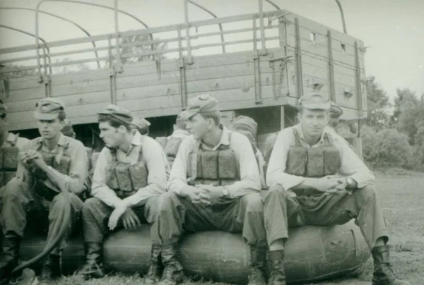 Foto retrô mostra jovens homens (soldados) durante o verão. Soldados posam com cintos de natação (colete) e sentam-se no barco de borracha. Fotografia vintage . — Fotografia de Stock
