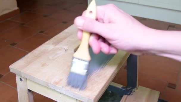 Les hommes peignent à la main les tabourets des meubles. Revêtement gris. Tabouret étape peinture avec couleur grise — Video