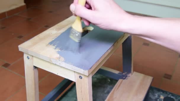 Les hommes peignent à la main les tabourets des meubles. Revêtement gris. Tabouret étape peinture avec couleur grise — Video