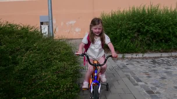 La niña monta en bicicleta. Hora de verano en la ciudad — Vídeos de Stock