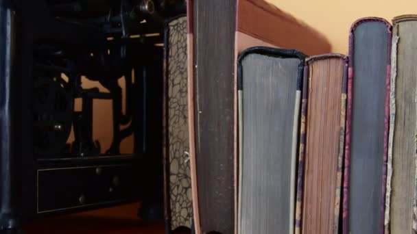 Винтажные книги. Вид ряда старых книг и винтажной пишущей машинки — стоковое видео