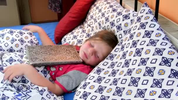 Niña en la cama. Las chicas que tratan de acostarse con un viejo diario de padre. Niña con un libro viejo en la cama. Concepto familiar — Vídeo de stock