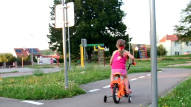 Girl rides the bike at playground traffic. Little girl on bike in the summer