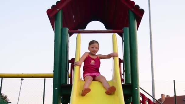 Blick auf Mädchen auf Rutsche auf Spielplatz — Stockvideo