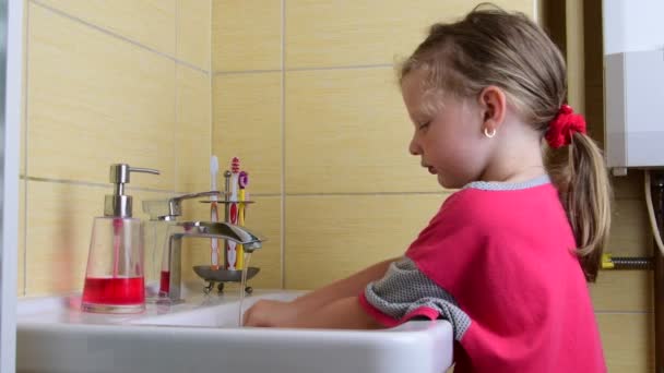 Doce menina lava as mãos na casa de banho. Conceito pré-escolar, conceito infantil. Menina bonito usa camisola — Vídeo de Stock