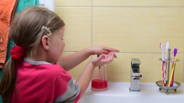 Édes kislány megmossa a kezét a fürdőszobában. Óvodai koncepciója, gyermekkor fogalma. Aranyos lány visel hálóruhaként — Stock videók